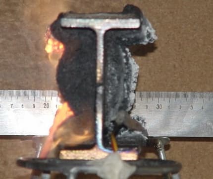 Perfil metálico com a camada de tinta intumescente carbonizando durante o ensaio de fogo